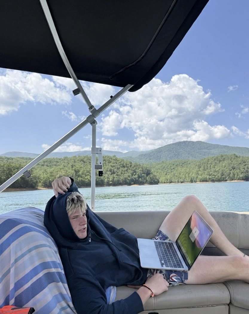 Working on a laptop on a pontoon boat on a mountain lake