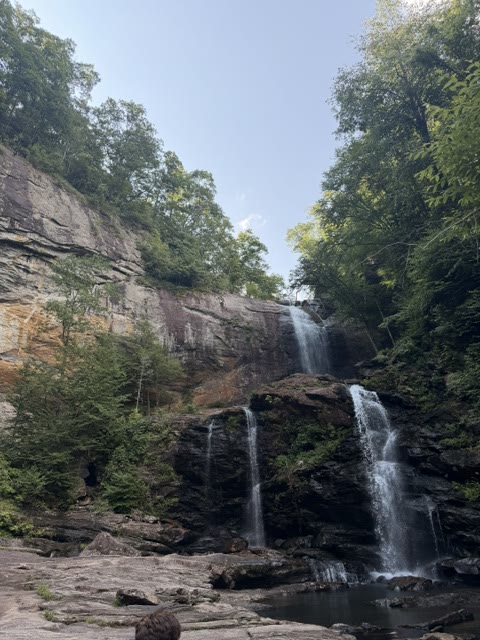 A tall waterfall cascading down a rock face in the forest